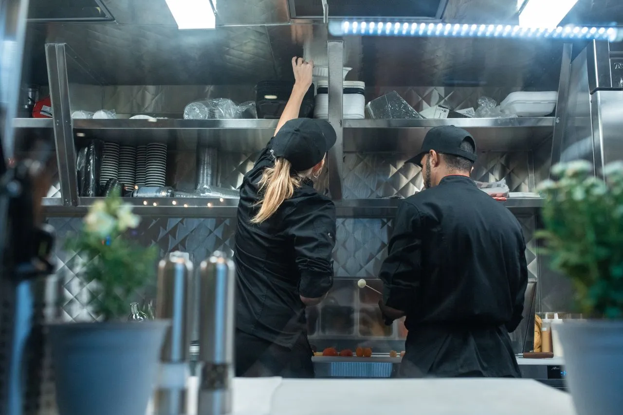 Dois cozinheiros trabalhando em uma cozinha profissional